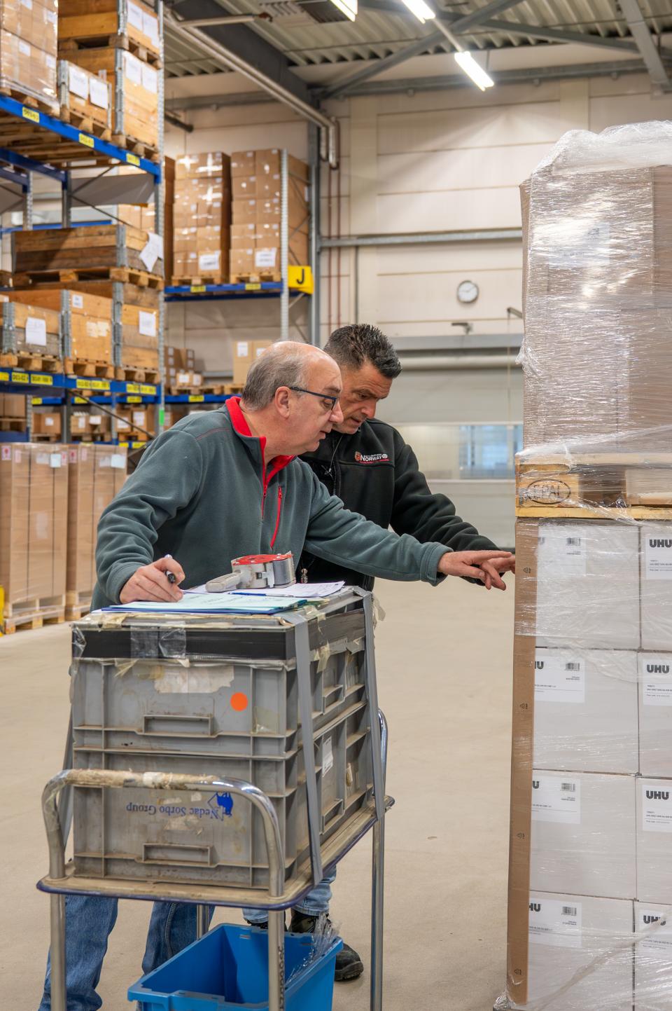 Twee magazijnmedewerkers controleren een paklijst