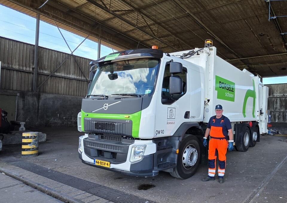 Vrachtwagen met man in oranje overal